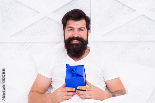 happy hipster with present box. early morning surprise. start day with birthday greeting. gift for spent night. bearded man spend holiday at home. valentines day. Special gift. Your order is ready photo