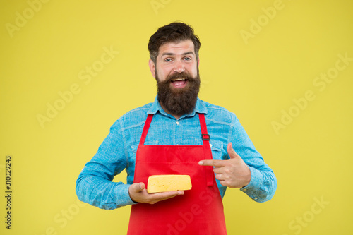 reasonable price and good quality. cheesemaking techniques. cheese maker. hipster with beard in chef apron. Dairy food shop. Online shopping. Gourmet product. happy bearded man hold cheese