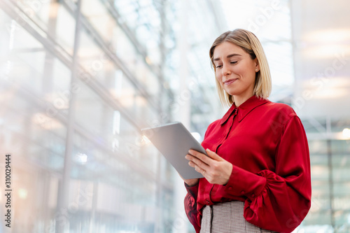 Young businesswoman wearing red shirt using tablet photo