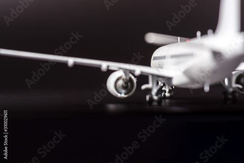 Blurred silhouette of a passenger plane on a black background : business travel concept