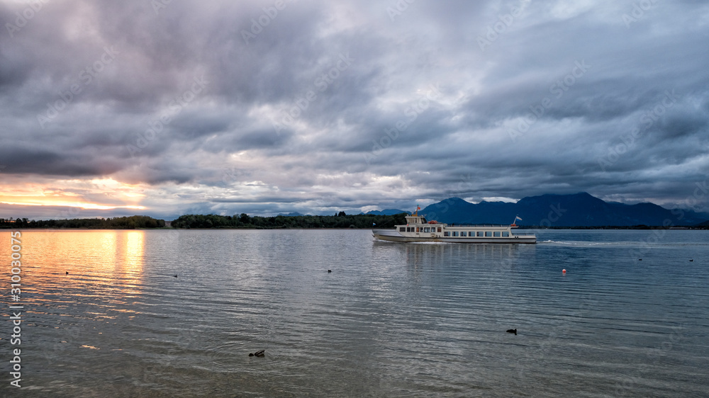 Dawn on Chiemsee Lake. In the foreground is a pleasure boat. Bavaria, Germany
