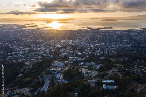 A serene sunset illuminates the densely populated San Francisco Bay area including Oakland, Berkeley, Emeryville, El Cerrito, and San Francisco in the distance. photo