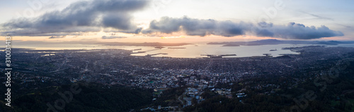 Fotografie, Obraz A serene sunset illuminates the densely populated San Francisco Bay area including Oakland, Berkeley, Emeryville, El Cerrito, and San Francisco in the distance