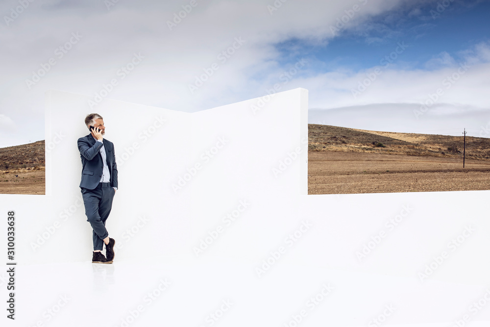 Businessman standing in empty space, talking on the phone Businessman standing in empty space, talking on the phone