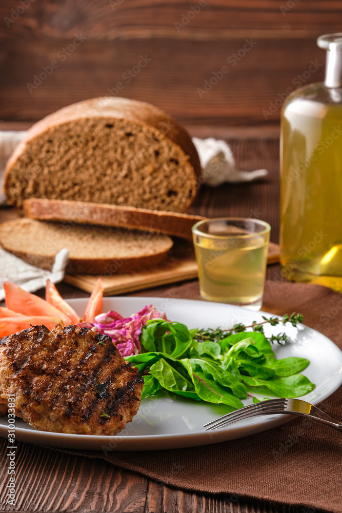 Grilled beef cutlet with fresh salad, brown bread and moonshine on rustic wooden table Grilled beef cutlet with fresh salad, brown bread and moonshine on rustic wooden table