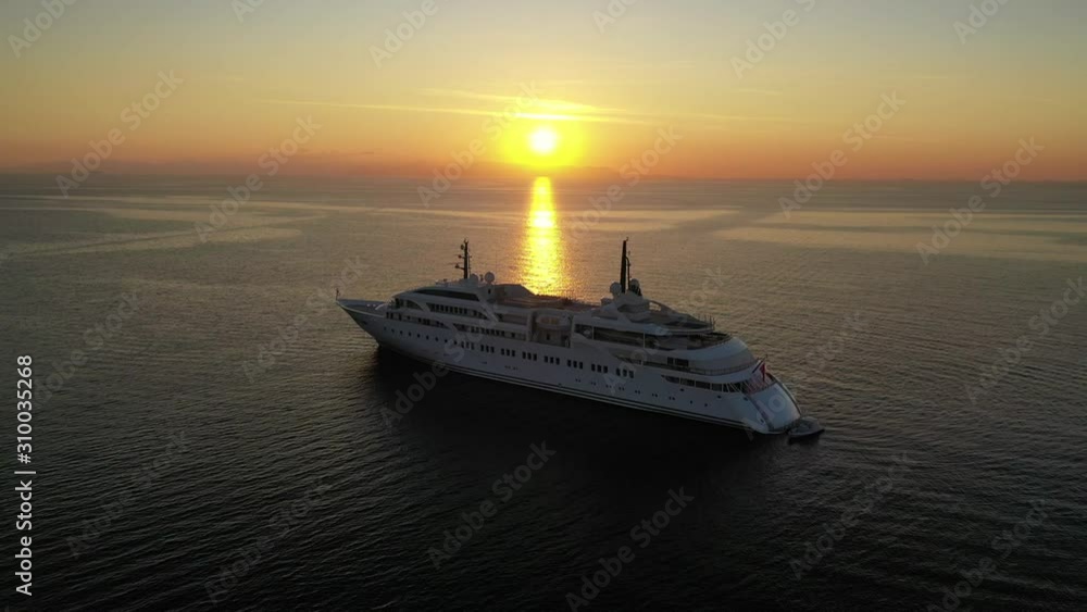 Aerial drone video of luxury yacht docked in Aegean deep blue sea at sunset with beautiful golden colours, Greece Aerial drone video of luxury yacht docked in Aegean deep blue sea at sunset with beautiful golden colours, Greece