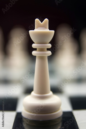 white king stands on a chessboard against the background of blurry remaining pieces