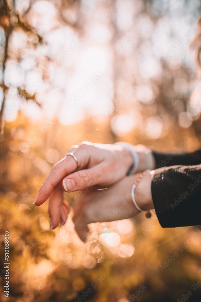 Woman's hands with rings and jewelry during autumn Woman's hands with rings and jewelry during autumn