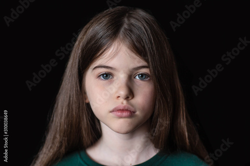Obraz na płótnie Closeup portrait of serious, sad little girl isolated on black background w salonie