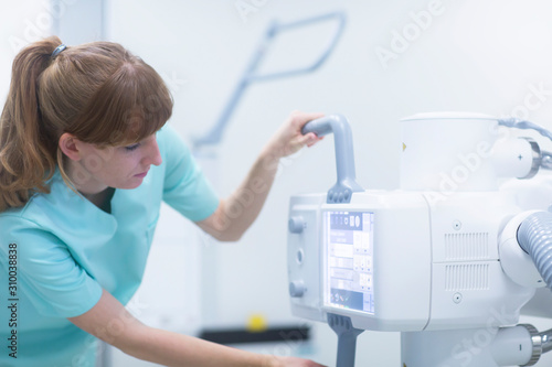 Female radiologist adjusting a x-ray machine
