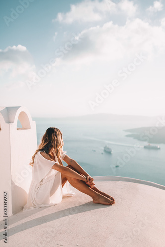 Young woman with blonde hair on rooftop in santorini greece