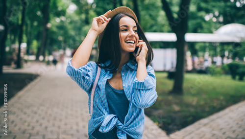 Successful hipster girl in trendy outfit rejoicing during international conversation with friend connected to roaming in trip,positive Caucasian tourist smiling while receiving good news via cellphone © GalakticDreamer