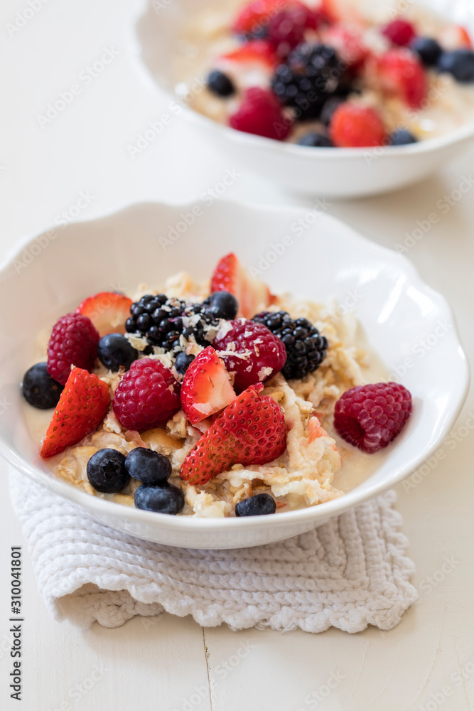 Bowls of fresh vegan muesli with various berries, currants and almond milk Bowls of fresh vegan muesli with various berries, currants and almond milk