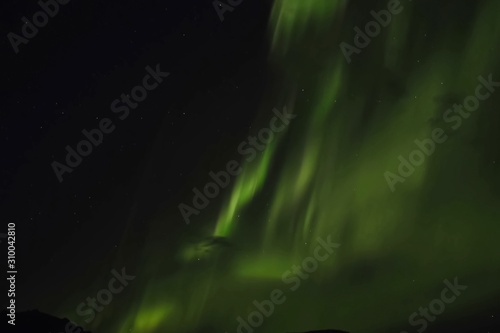 Aurora borealis in night northern sky. Ionization of air particles in the upper atmosphere.