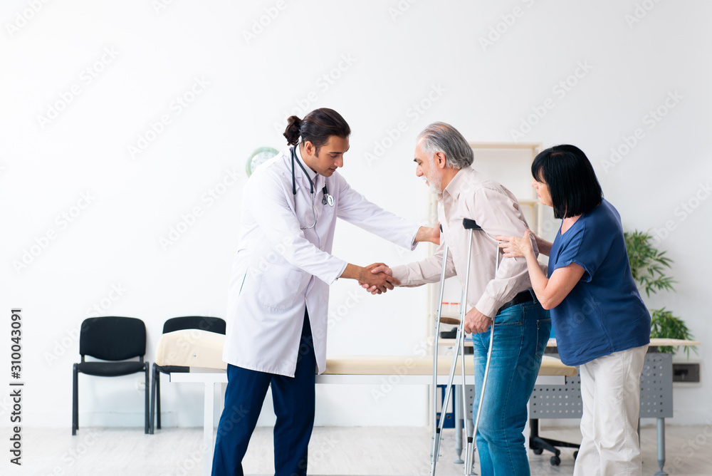 Old couple visiting young male doctor