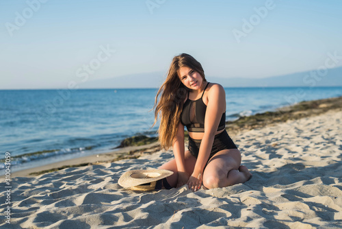 Cheerful plus size teenage girl enjoying the beach. smiling, happy, positive emotion, summer style.