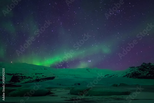 Fototapeta Naklejka Na Ścianę i Meble -  Aurora borealis in night northern sky. Ionization of air particles in the upper atmosphere.