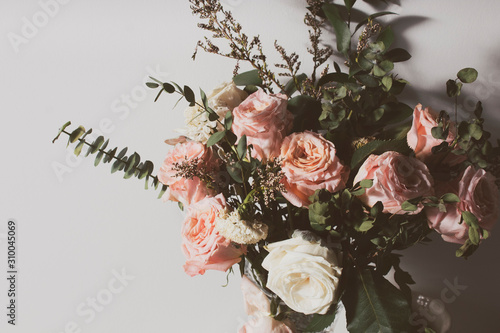 vintage aromatic dried rose flower and natural leaf with white wall in valentine's day love romantic concept, wedding decoration flora tree photo