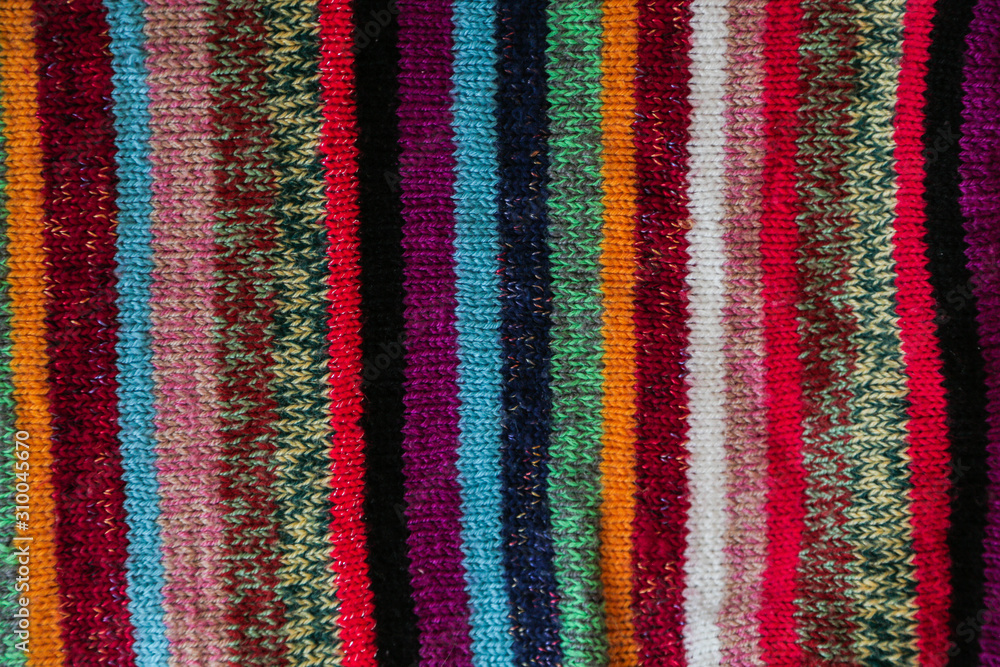 Obraz premium Colorful stripy woolen fabric texture close up. knitted background. Close up texture . wrinkled and shadows, top view