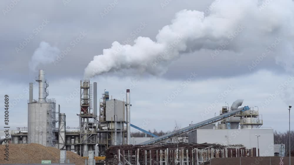 An industrial zone with large chimney, thick white smoke pours out of factory chimney at sunset, against background of thick clouds. Environmental pollution: smoke pipe. Seamless cinemagraph video. An industrial zone with large chimney, thick white smoke pours out of factory chimney at sunset, against background of thick clouds. Environmental pollution: smoke pipe. Seamless cinemagraph video.