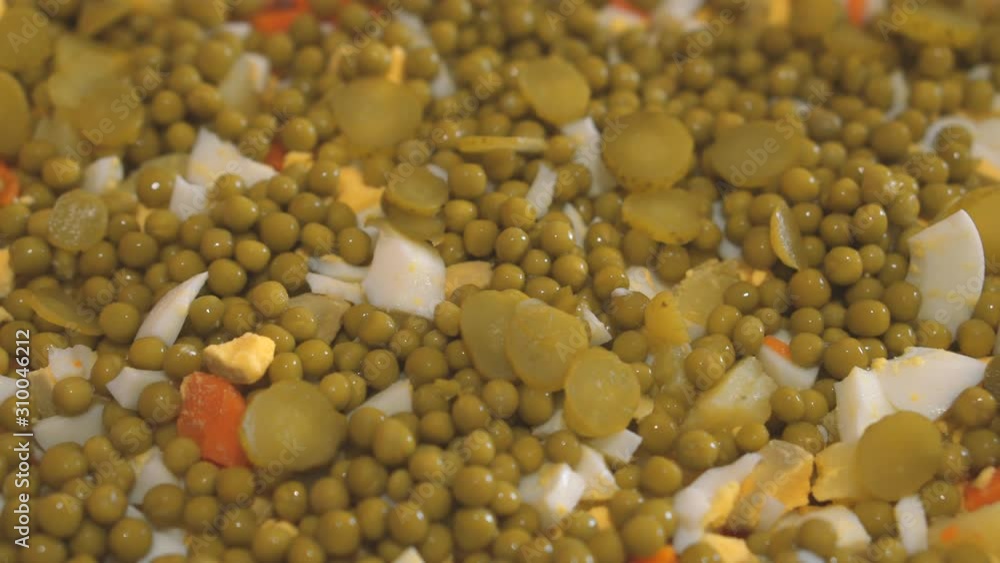 Olivier salad. Close-up. Salad of potatoes, green peas, carrots, cucumbers, eggs, meat and mayonnaise. Cooking food Olivier salad. Close-up. Salad of potatoes, green peas, carrots, cucumbers, eggs, meat and mayonnaise. Cooking food