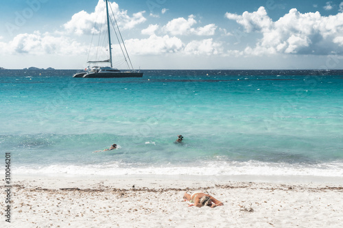 Canvas Print un catamaran au large d'une plage paradisiaque avec 2 baigneurs