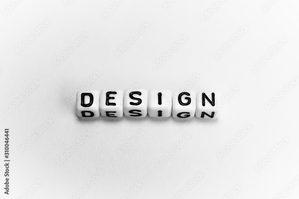 White cubes with word DESIGN on white paper background and dark shadows White cubes with word DESIGN on white paper background and dark shadows
