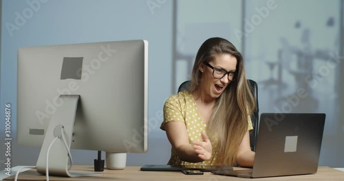 good looking female graphic designer finishing her work day in her advertising agency office. slow motion 4k.