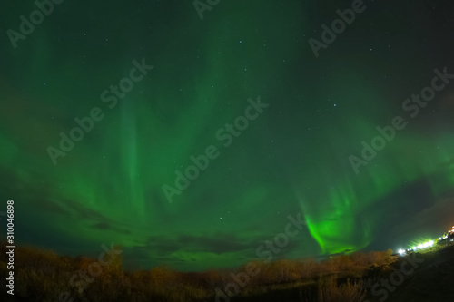 Aurora borealis in night northern sky. Ionization of air particles in the upper atmosphere.