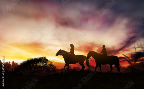 Couple on horseback at sunset