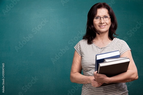 Smile woman teacher with books on background