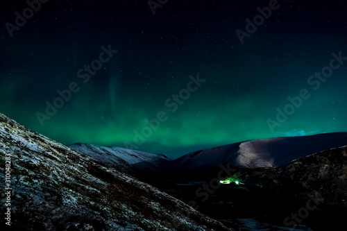 Aurora borealis in night northern sky. Ionization of air particles in the upper atmosphere.