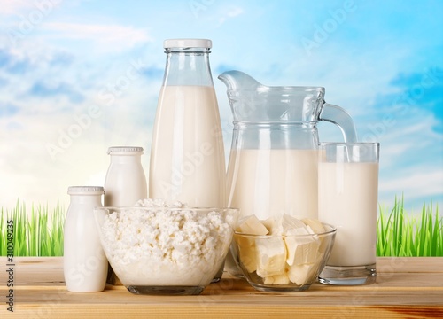 Glass of milk and dairy products on background