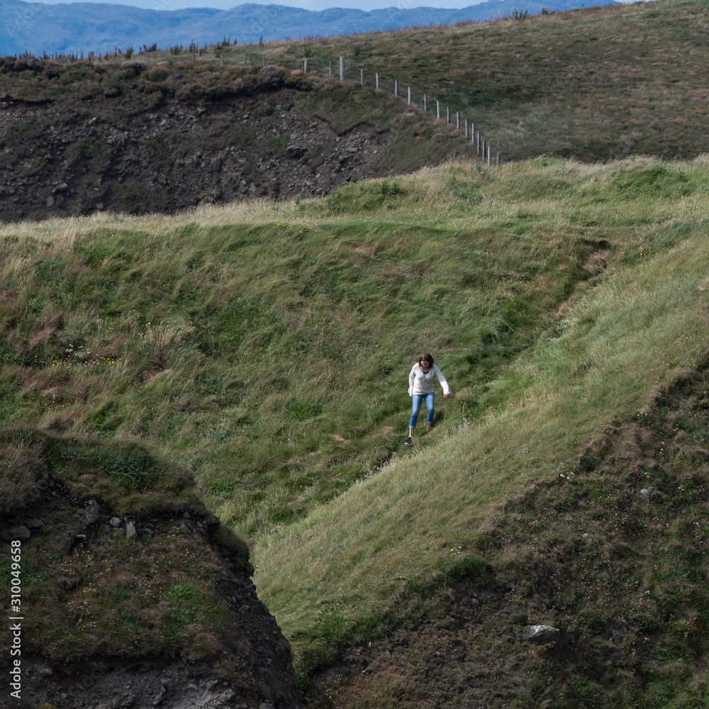 Woman climbing the hills of Mullaghmore Peninsula, County Sligo, Ireland