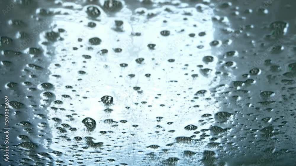 Close view of water and detergent on windscreen or windshield of car in drive through touchless car wash Close view of water and detergent on windscreen or windshield of car in drive through touchless car wash