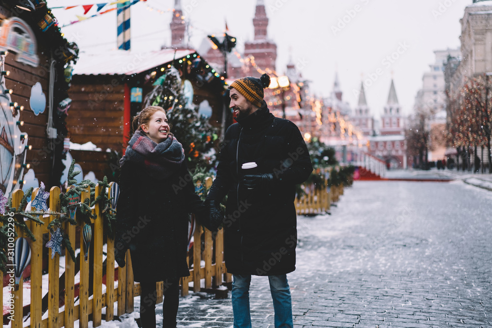 Obraz premium Young couple holding hands and walking on Red Square
