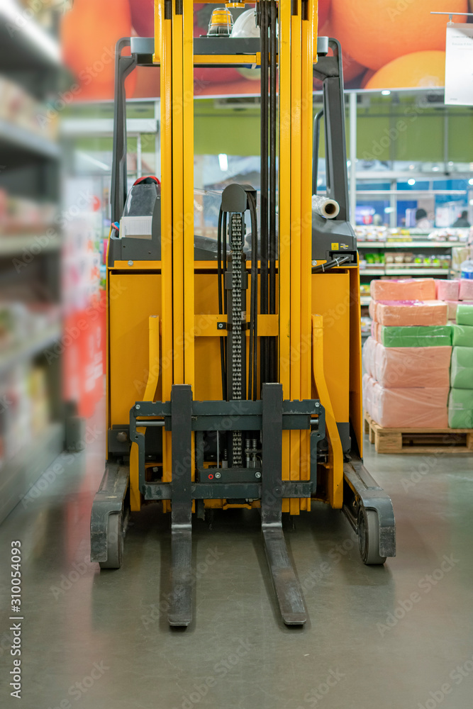 forklift in the warehouse working and lifting the boxes of new income products forklift in the warehouse working and lifting the boxes of new income products