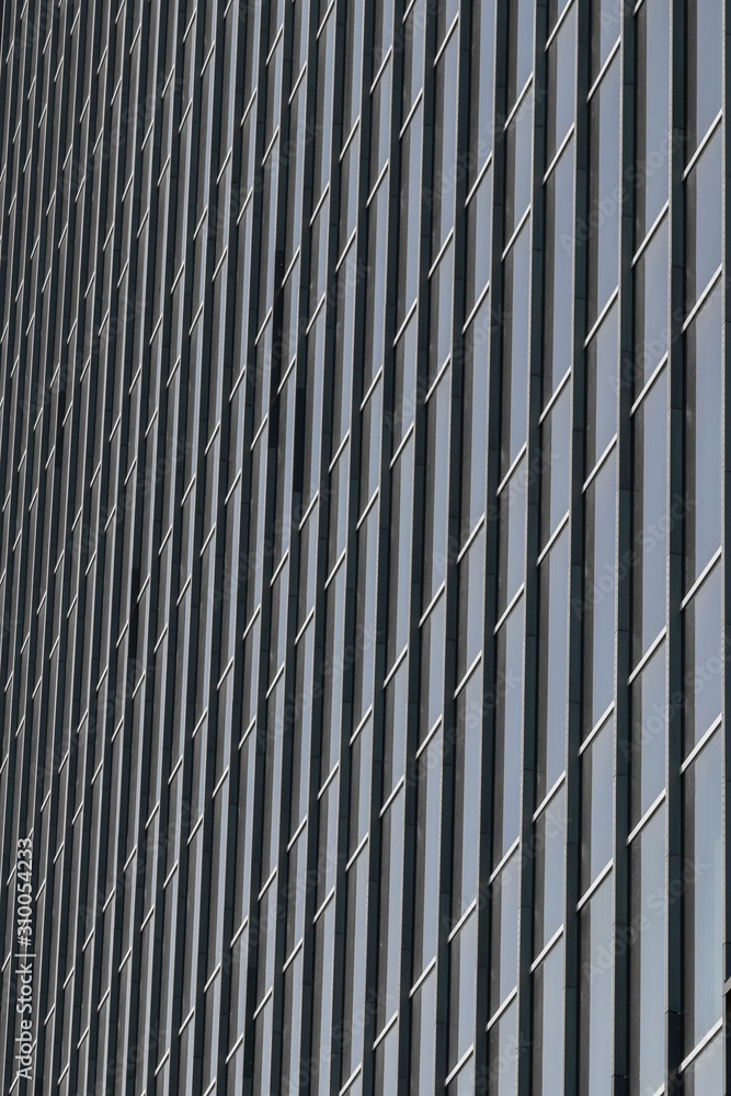 Modern house wall of business center, geometric lines and patterns. Metal details of building's facade abstract background with vertical stripes Modern house wall of business center, geometric lines and patterns. Metal details of building's facade abstract background with vertical stripes