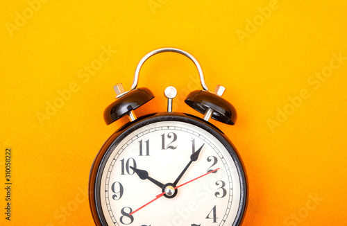 Vintage style alarm clock on yellow background banner with copy space