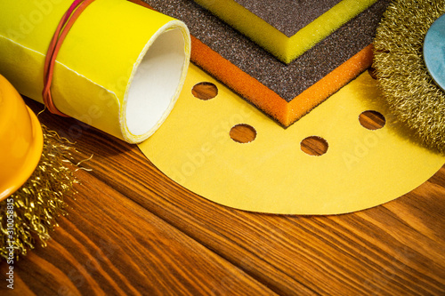 Set of abrasive tools and yellow sandpaper on vintage wooden background