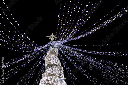 Modern glowing Christmas tree on black background.
