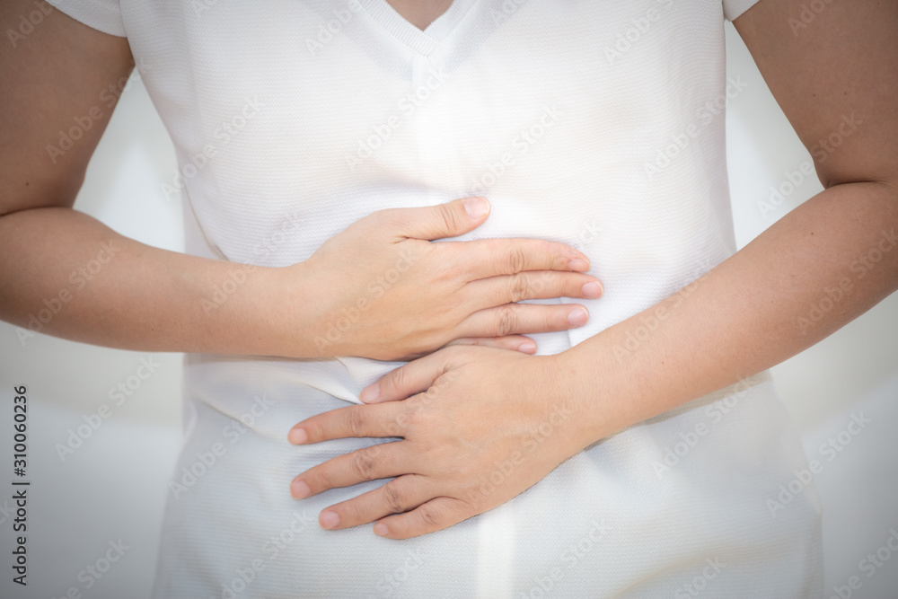 The image of an Asian woman holding her hand in her stomach because of a stomachache, because of a stomachache and having food-borne infections in a white background. The image of an Asian woman holding her hand in her stomach because of a stomachache, because of a stomachache and having food-borne infections in a white background.