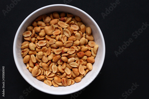 Peanuts in a white bowl with a dark background