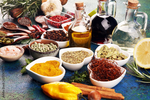 Fototapeta Spices and herbs on table. Food and cuisine ingredients with oil and vinegar