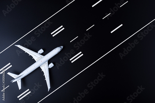 Airplane on black runway. Top view on aircraft. Concept of business travel and aerospace indusrty
