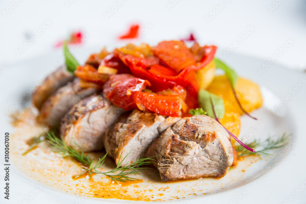 Roasted pork fillet with vegetables on a plate Roasted pork fillet with vegetables on a plate