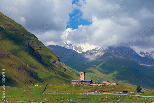 View of the Ushguli village at the foot of Mt. Shkhara. Lamaria Monastery, old Rock tower. photo