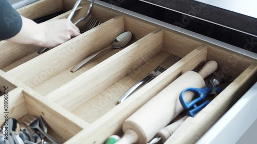 pulling the cutlery out of the cutlery drawer