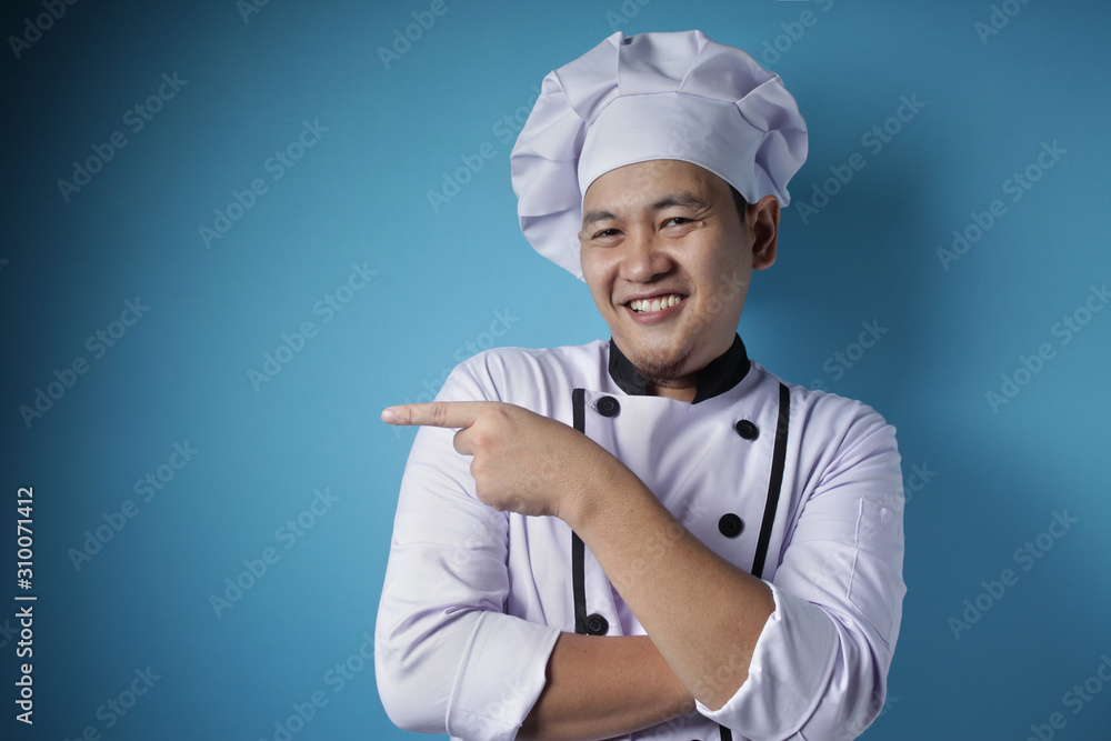 Naklejka premium Happy Smiling Asian Chef Pointing Presenting Something on His Side