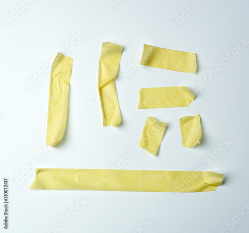 set of various pieces of yellow sticky paper tape on a white background